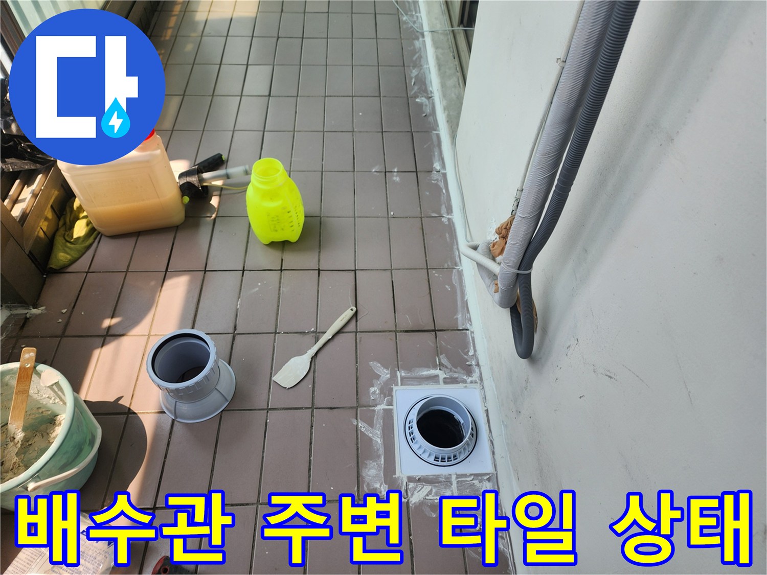 배수관 입구와 주변 타일 마감 상태를 촬영한 사진입니다