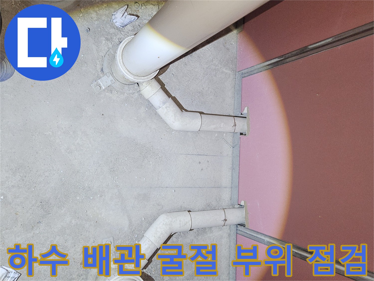 바닥으로 들어가는 하수 배관의 연결 지점을 가까이서 찍은 사진입니다.