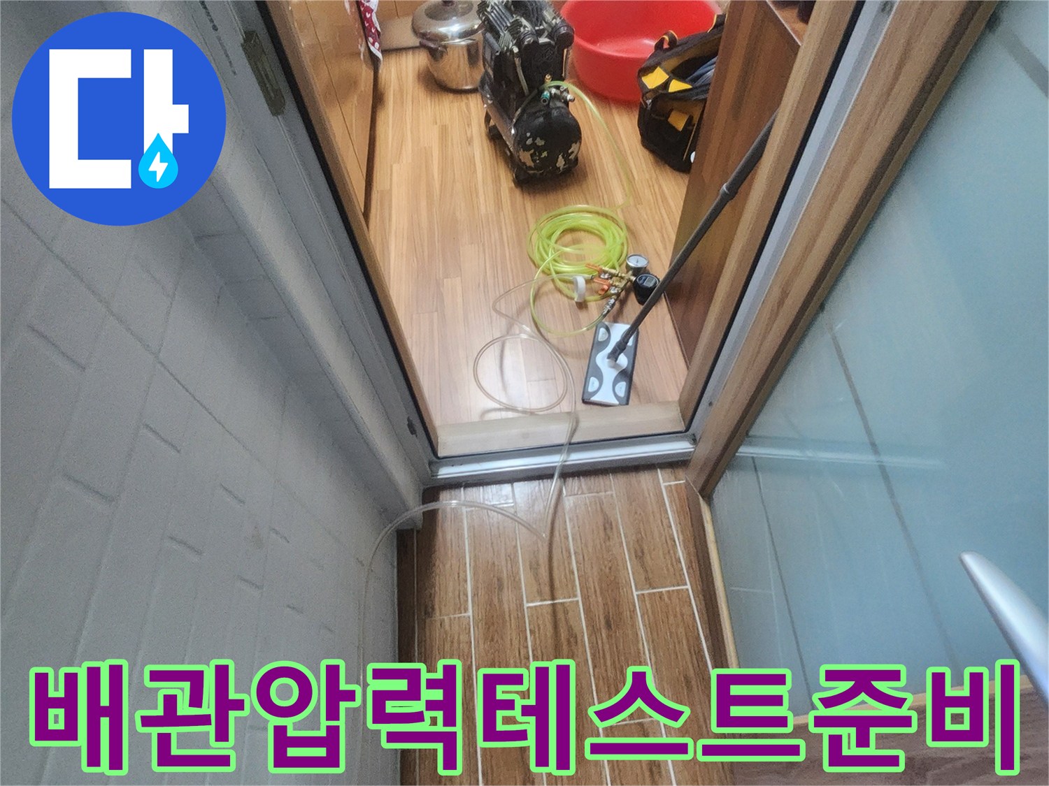 아파트 내부에서 누수 엔지니어가 배관 압력-테스트를 위한 장비 연결을 진행하고 있습니다.