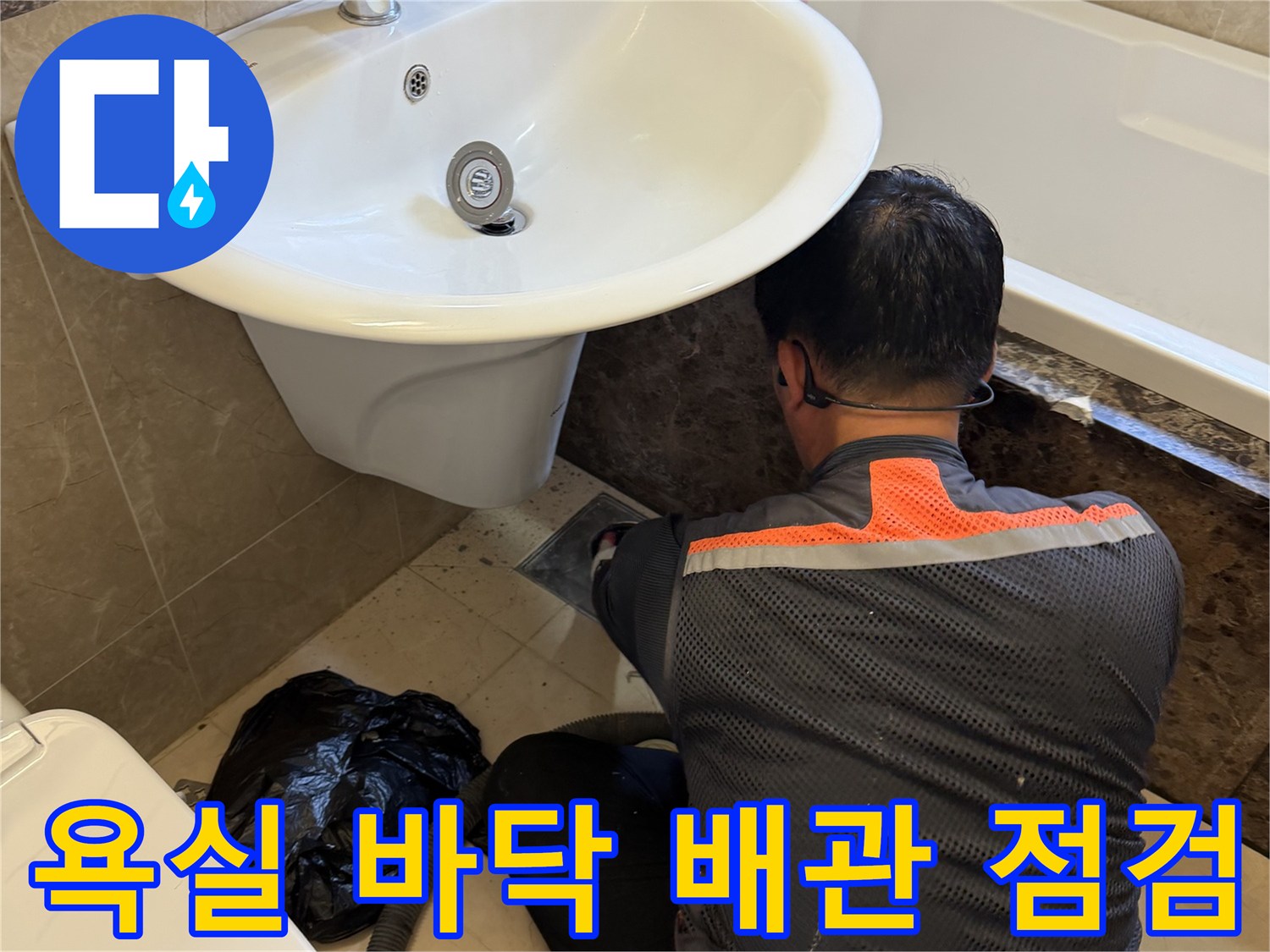 작업자가 세면대 아래 타일 틈새를 확인하며 누수를 진단합니다