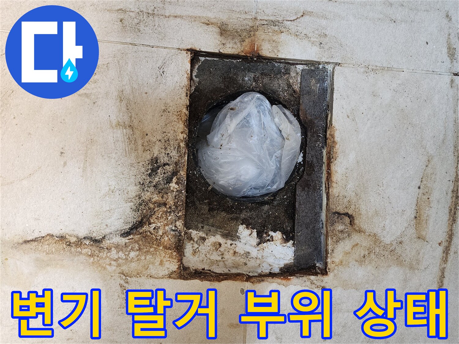 변기를 제거한 후 나타난 오염된 배관 입구와 타일
