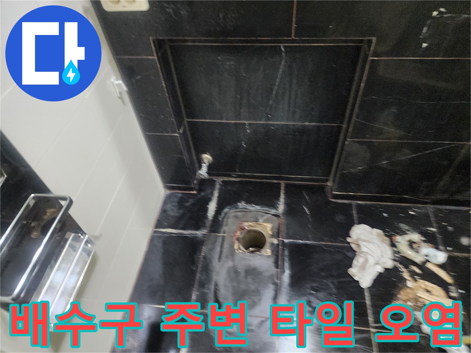 검게 변한 타일과 노출된 배관 입구 근접 촬영