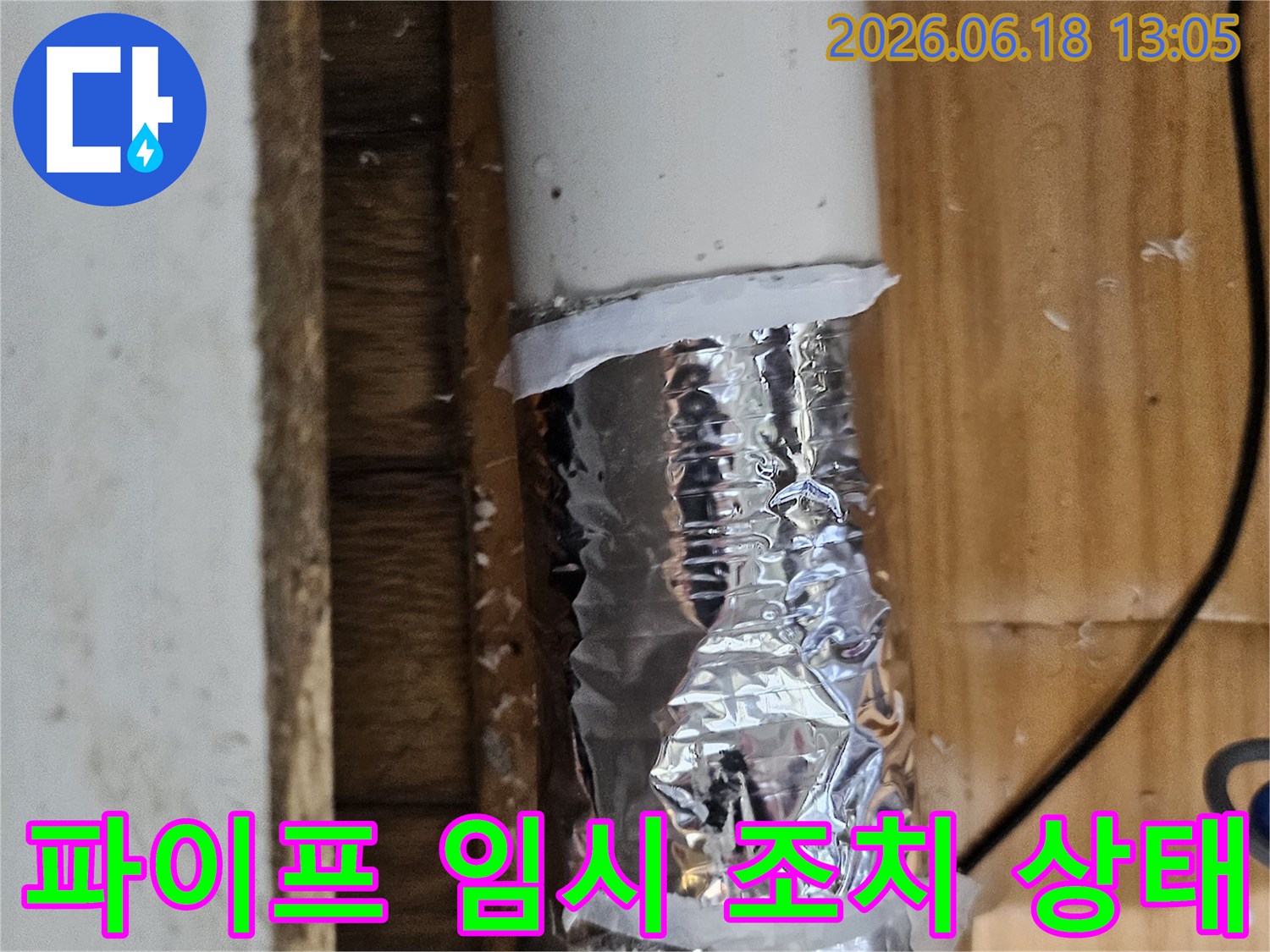 손상된 배관 부위를 알루미늄 호일과 테이프로 임시 보수한 모습-누수 공사 전 단계