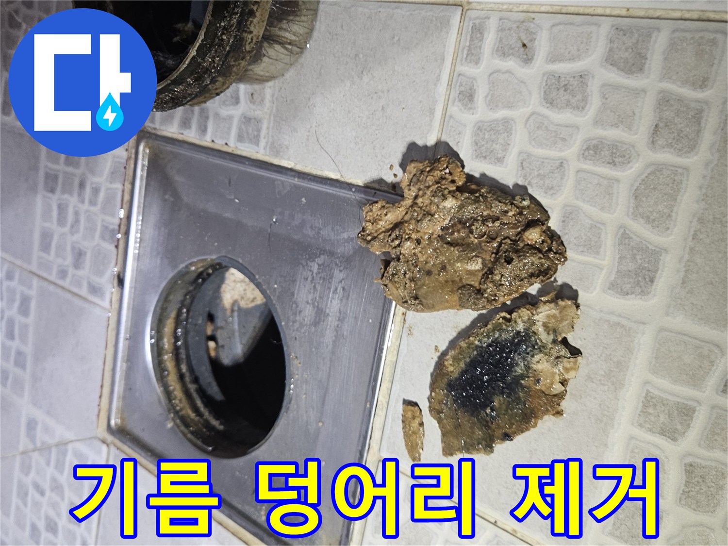 배관 입구에 걸려 있는 검고 커다란 기름 슬러지 덩어리