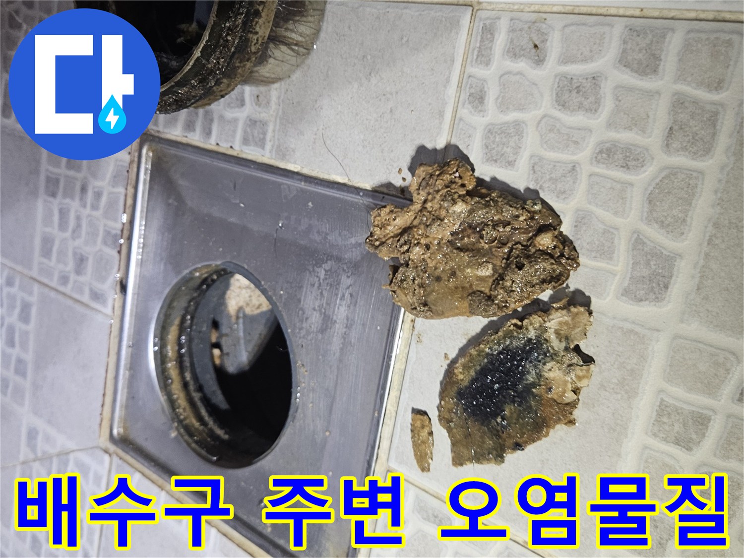 싱크대 배수구 옆 타일에 뭉쳐 있는 검은색 슬러지 조각