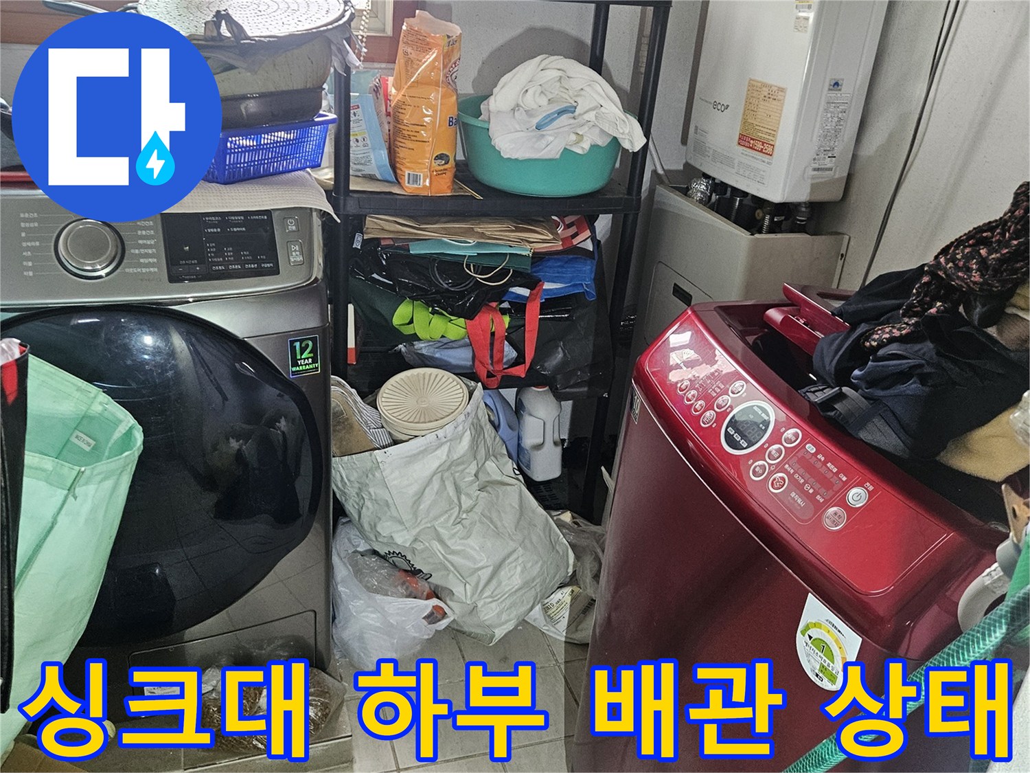 싱크대 아래쪽의 세탁기 주변 및 배수 설비 점검 사진입니다.