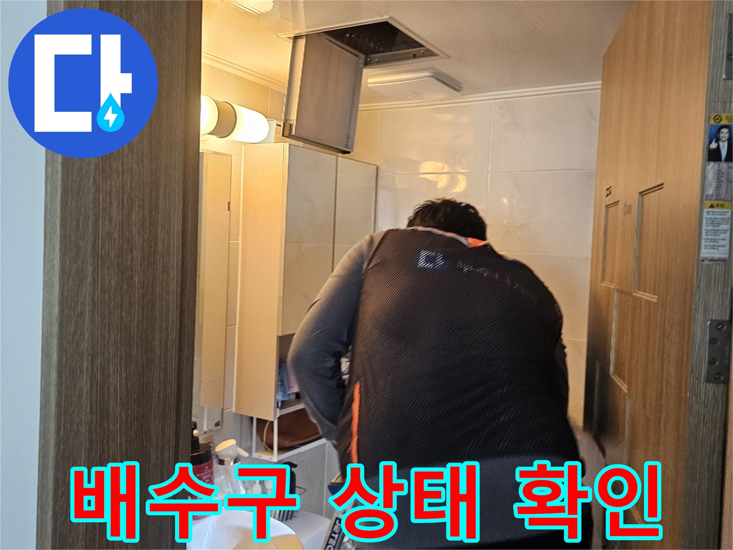 싱크대 하단 배관 부근을 점검하며 누수 지점을 찾는 작업자