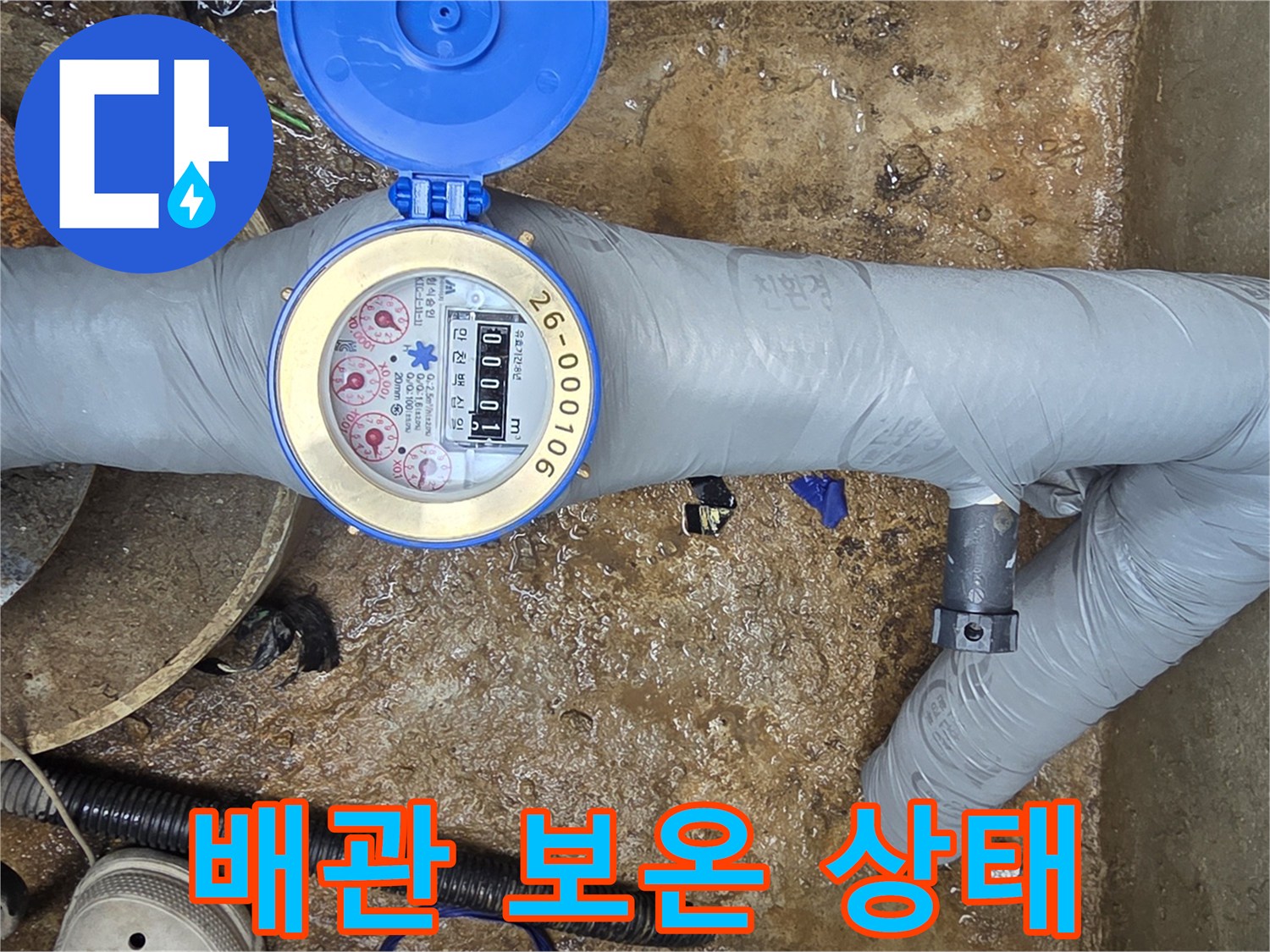 보온재로 마감된 배관과 수치가 표시되는 수도 계량기 사진
