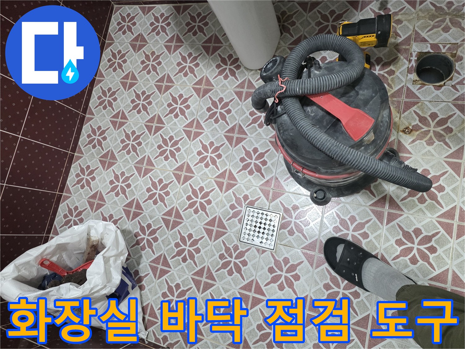 화장실-바닥-타일-위의-청소용-진공흡입기-및-작업-도구
