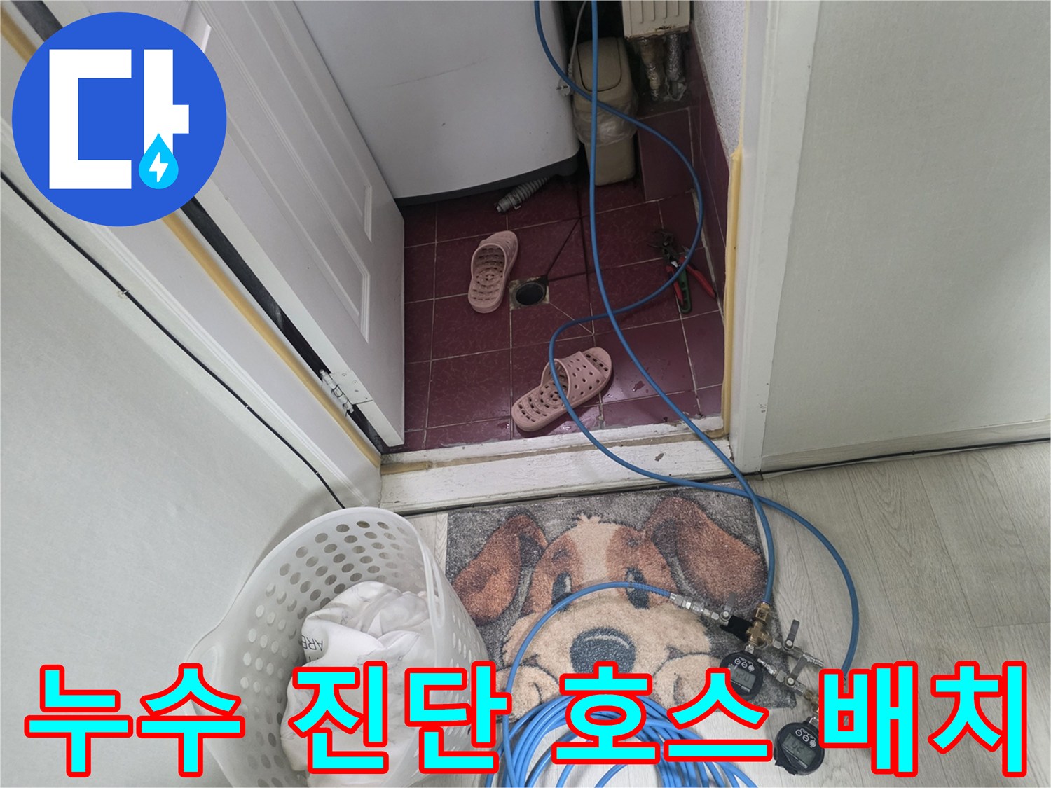 화장실-입구-바닥-에-연결된-파란색-누수-검사-용-호스-및-장비