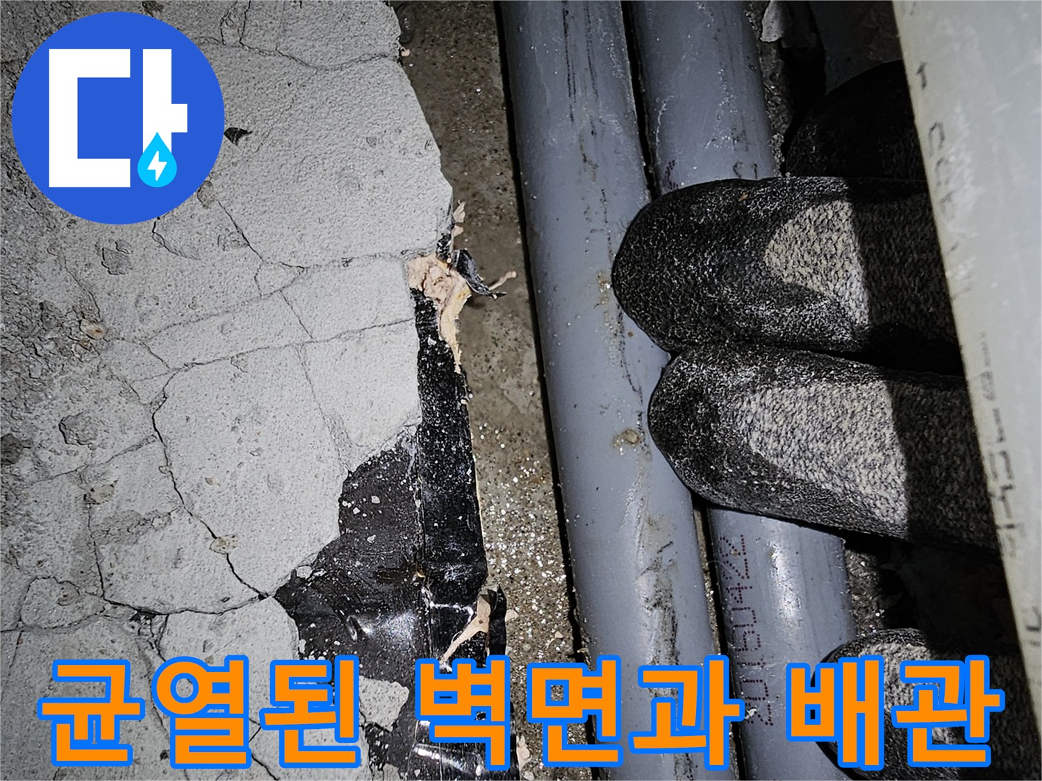 균열이 발생한 콘크리트 벽면-노출된 수도 배관