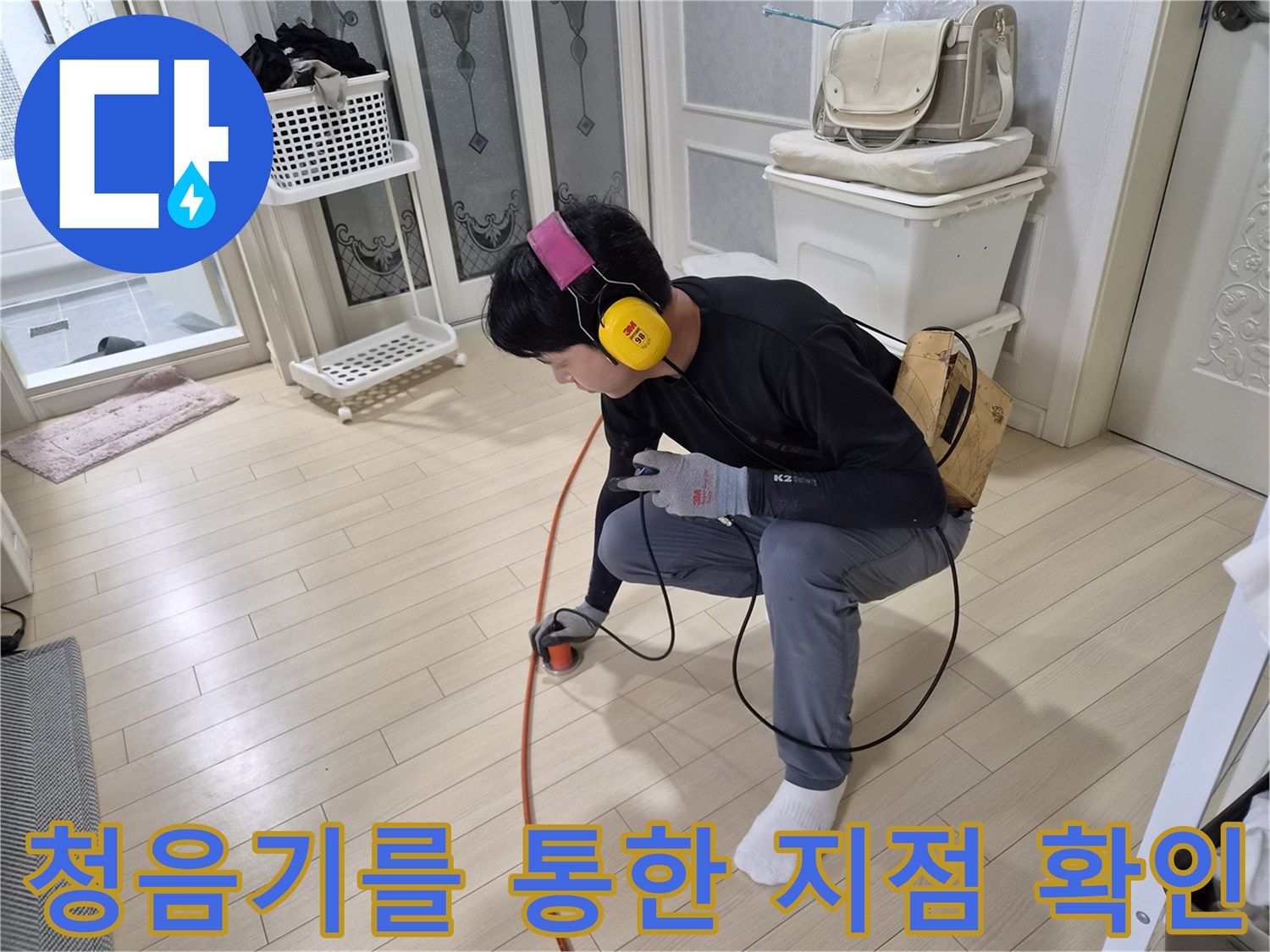 바닥 배관의 소리를 듣기 위해 청음 장비를 사용 중인 작업자