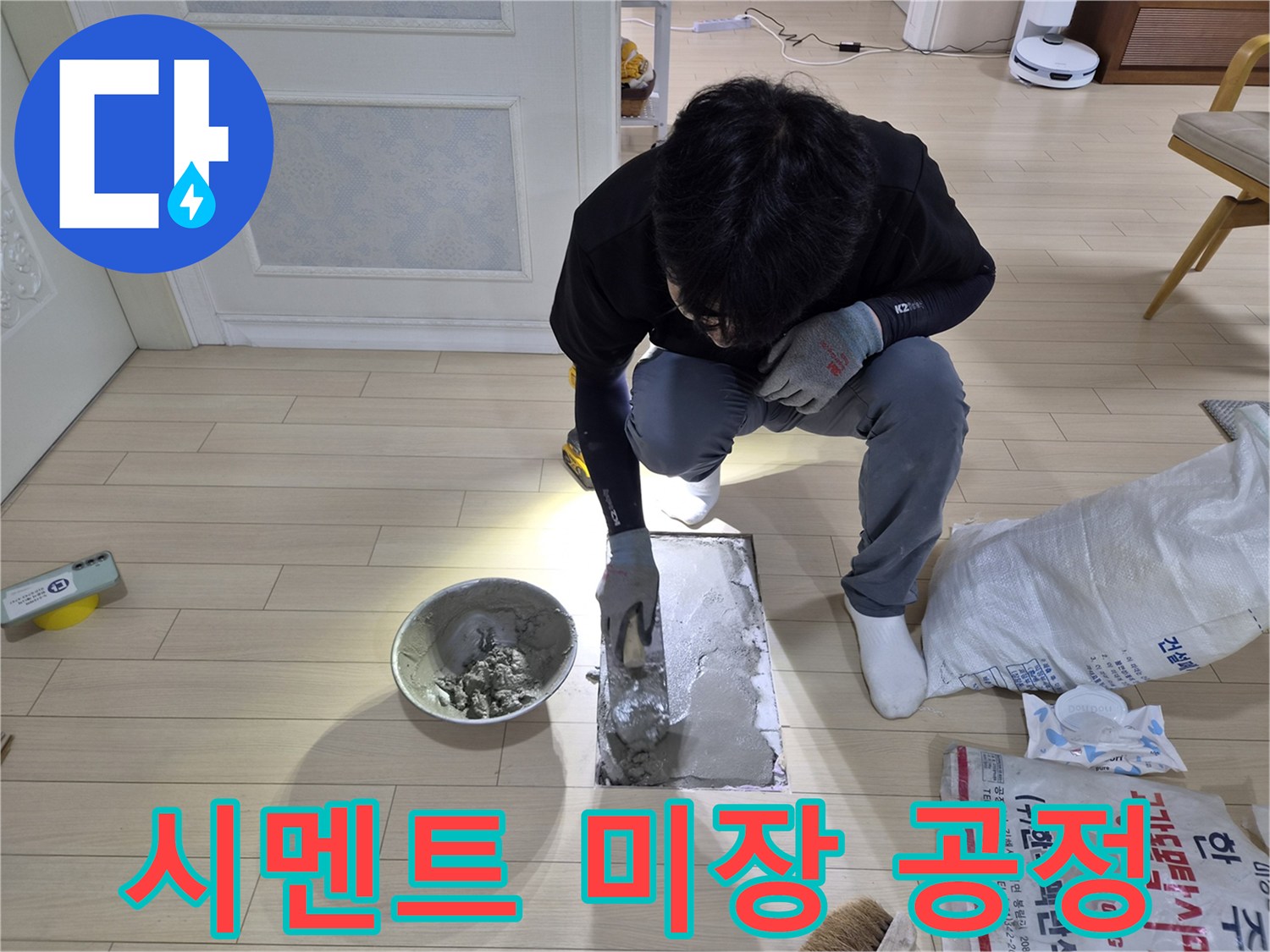 배관 수선 부위를 덮기 위해 시멘트를 도포하는 작업자