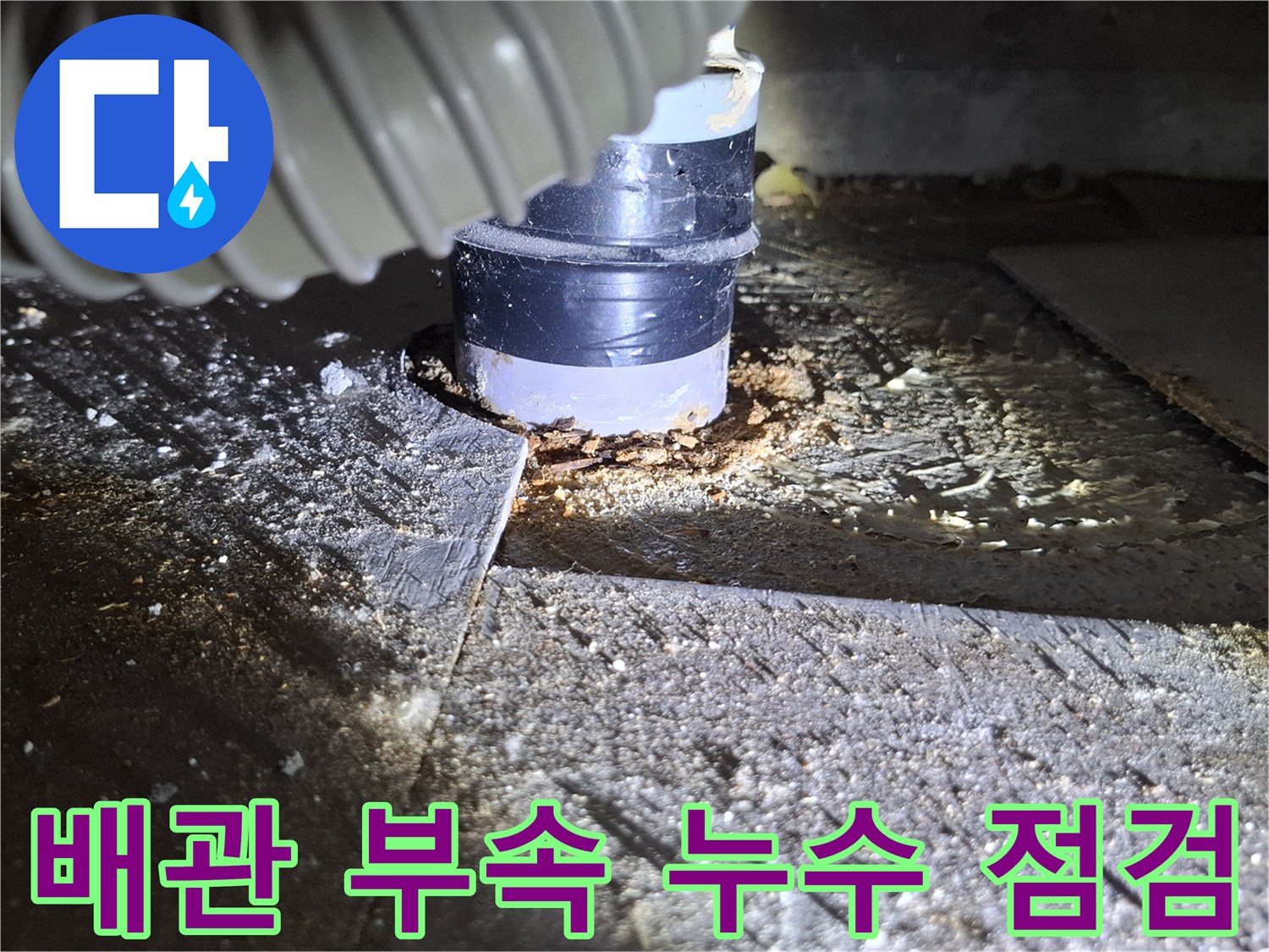 배관 연결 소켓 주변의 습기와 젖은 바닥 상태를 클로즈업한 사진입니다.