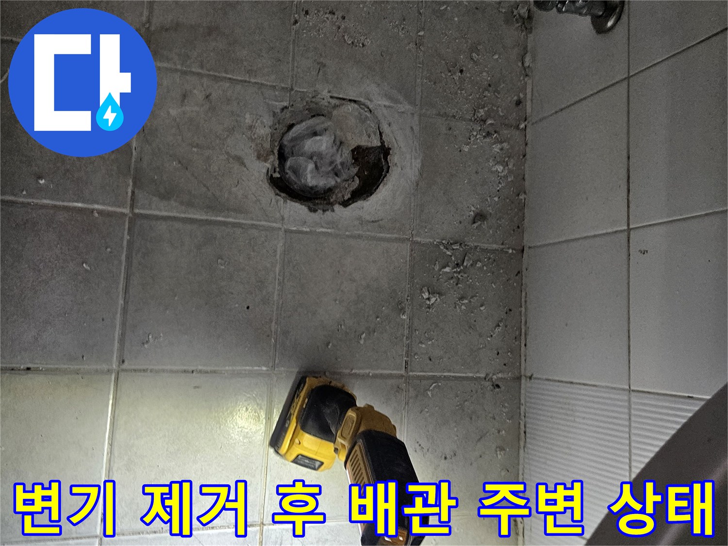 배관 주위의 젖은 바닥 면과 작업 도구들