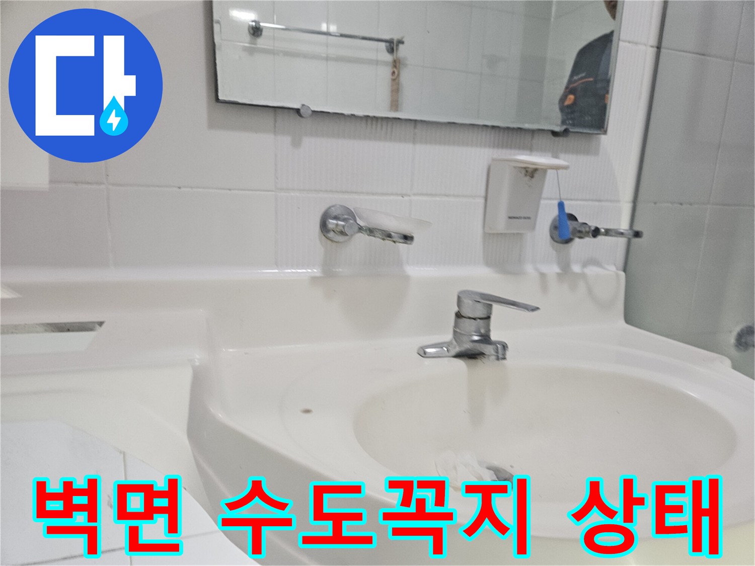 세면대 위쪽 벽면에 설치된 은색 수전입니다.