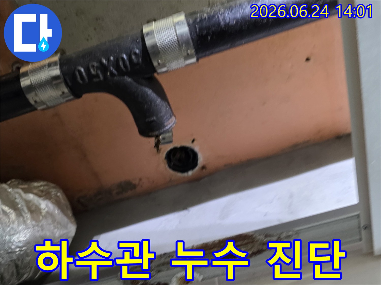 하수관에서 물이 새어 나와 천장에 물 자국과 손상을 일으키는 현장을 담은 사진입니다