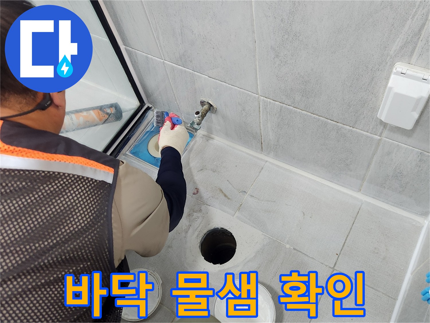 배수구 근처 타일 틈새를 조사하며 누수 경로를 찾는 모습