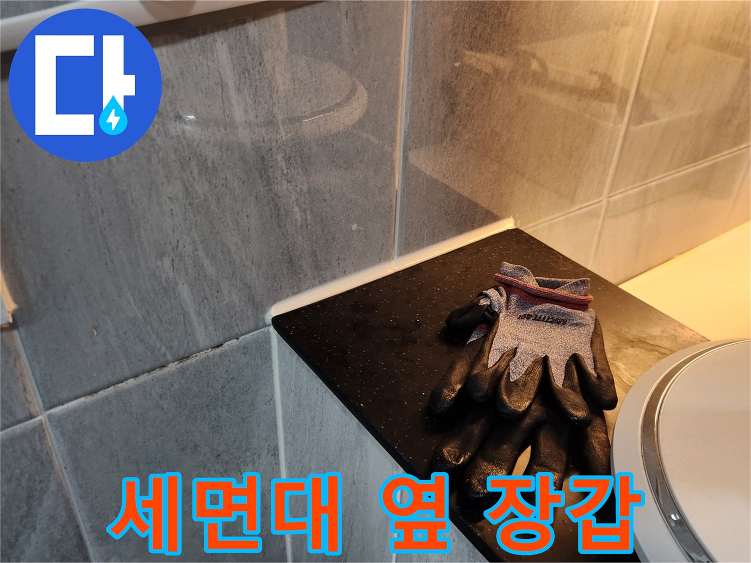세면대 하단 타일 앞의 작업용 장갑
