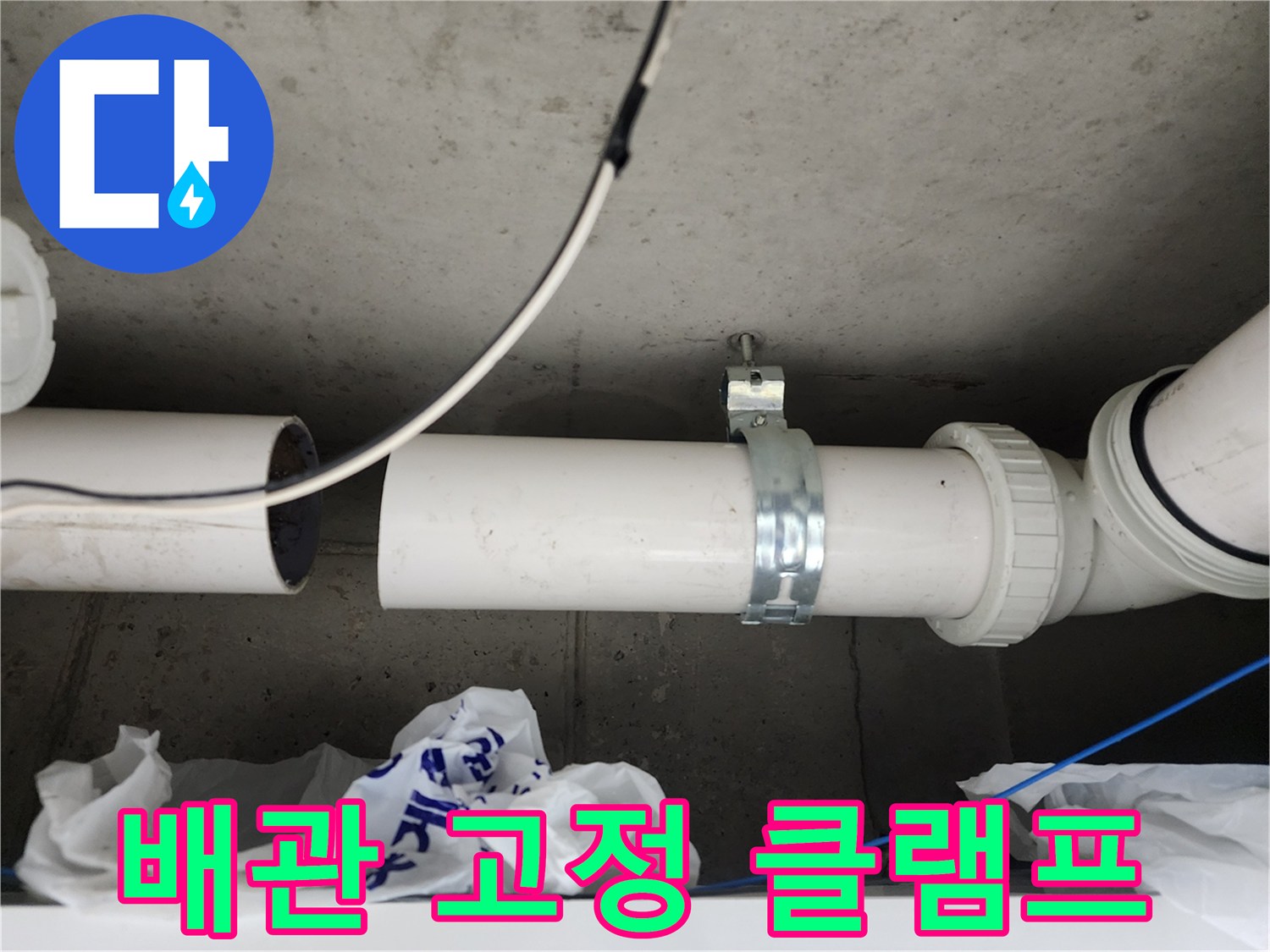 금속제 클램프로 고정된 하수 배관의 상세 모습
