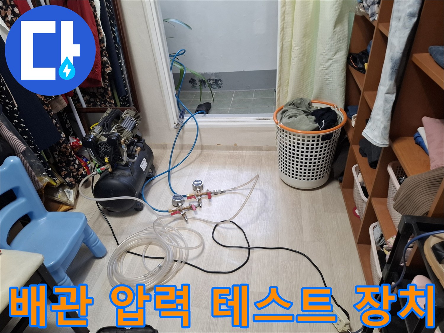 바닥에 배치된 공압 테스트용 컴프레서와 연결 호스 구성입니다.