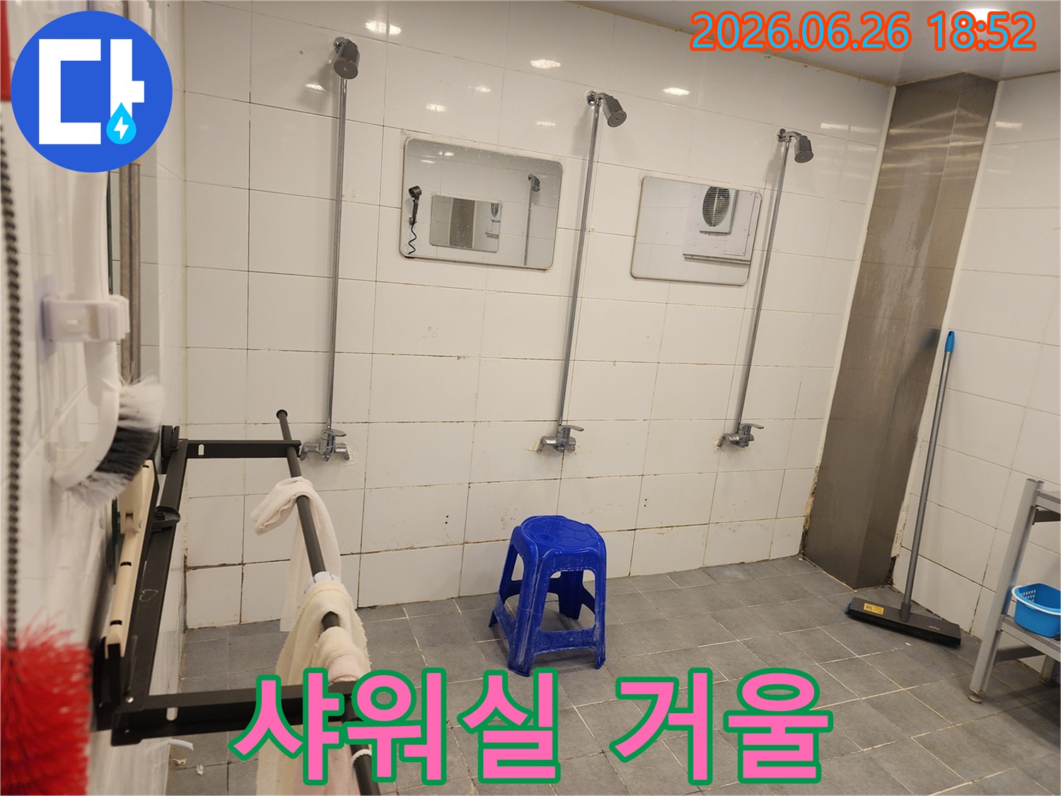 샤워실 벽면에-설치된-거울과-그 주변의-타일-그리고-수도꼭지의-모습