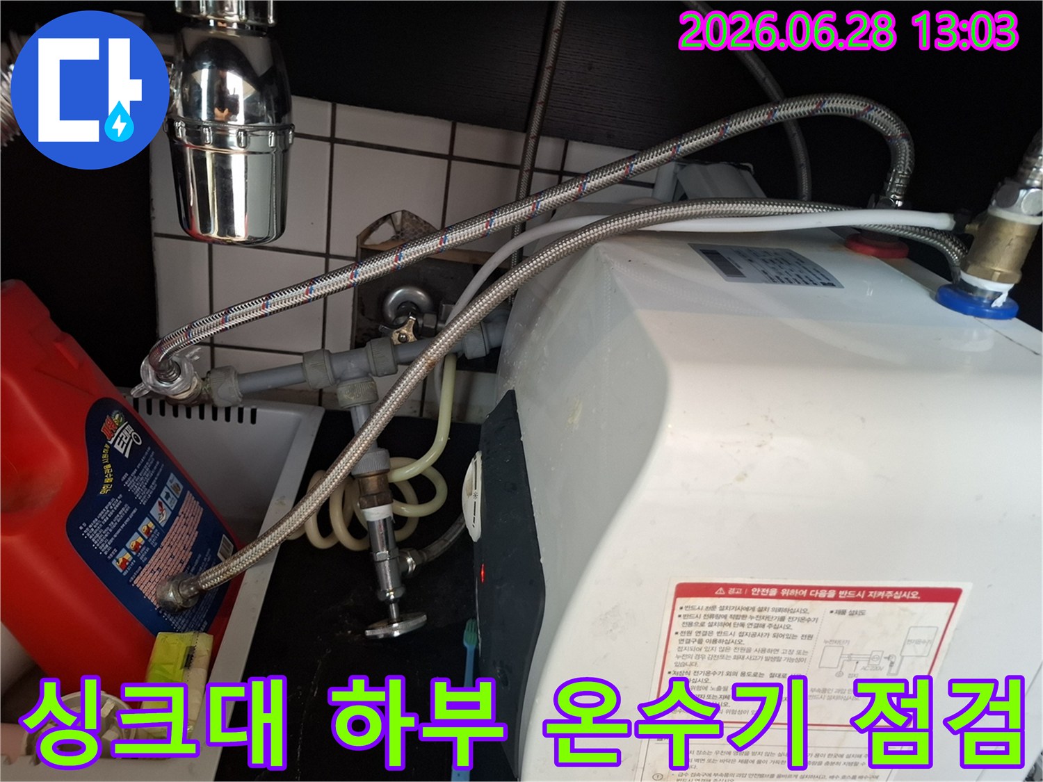 싱크대-아래-설치된-온수기와-그에-연결된-복잡한-배관-시스템을-전문가가-진단하는-모습입니다.
