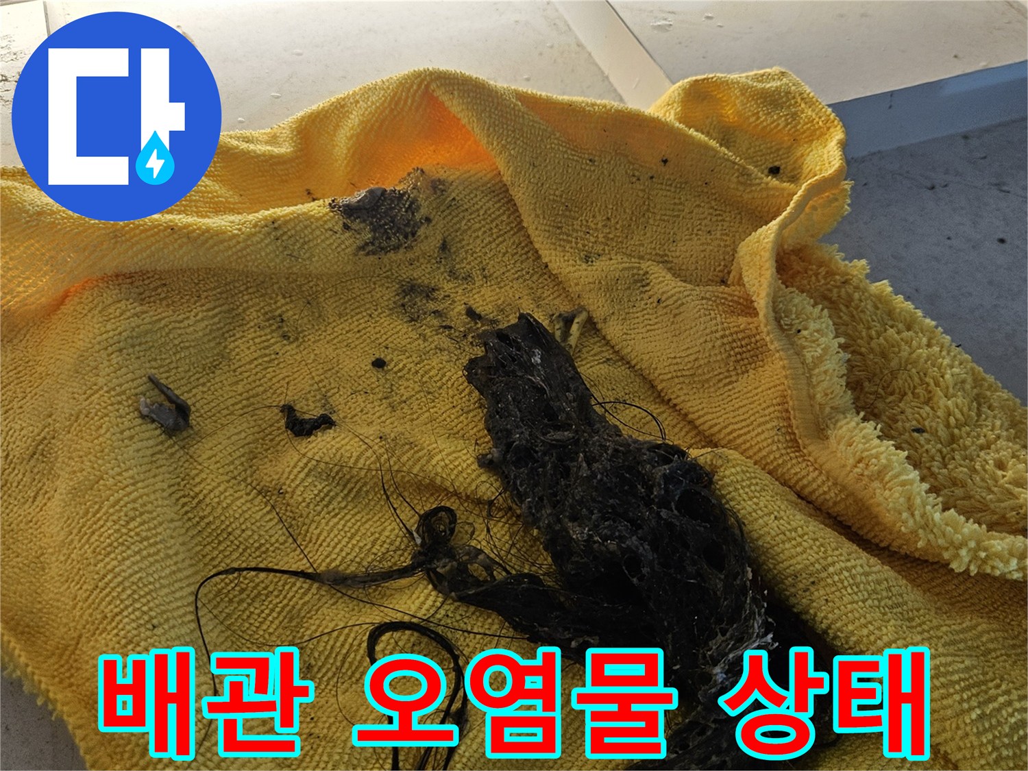 노란 수건 위에 쌓여 있는 검은색 배관 슬러지