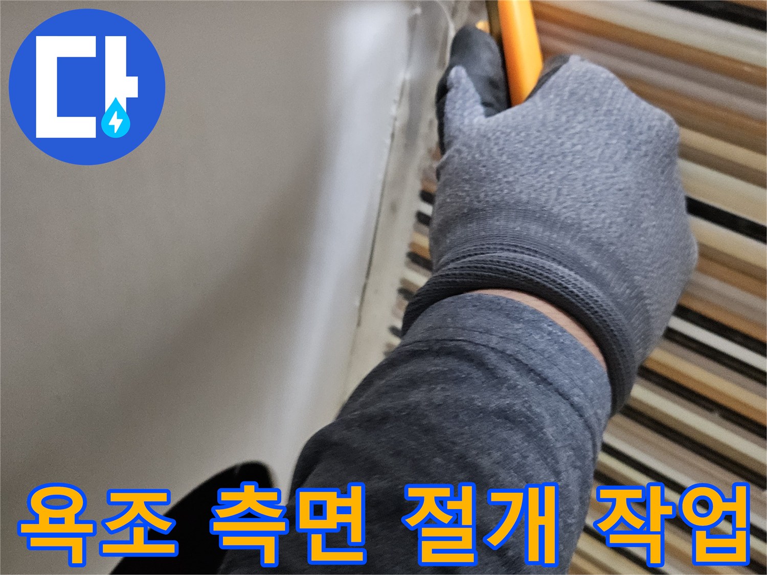 노란색 도구를 사용하여 욕조의 흰색 마감재를 제거하는 모습