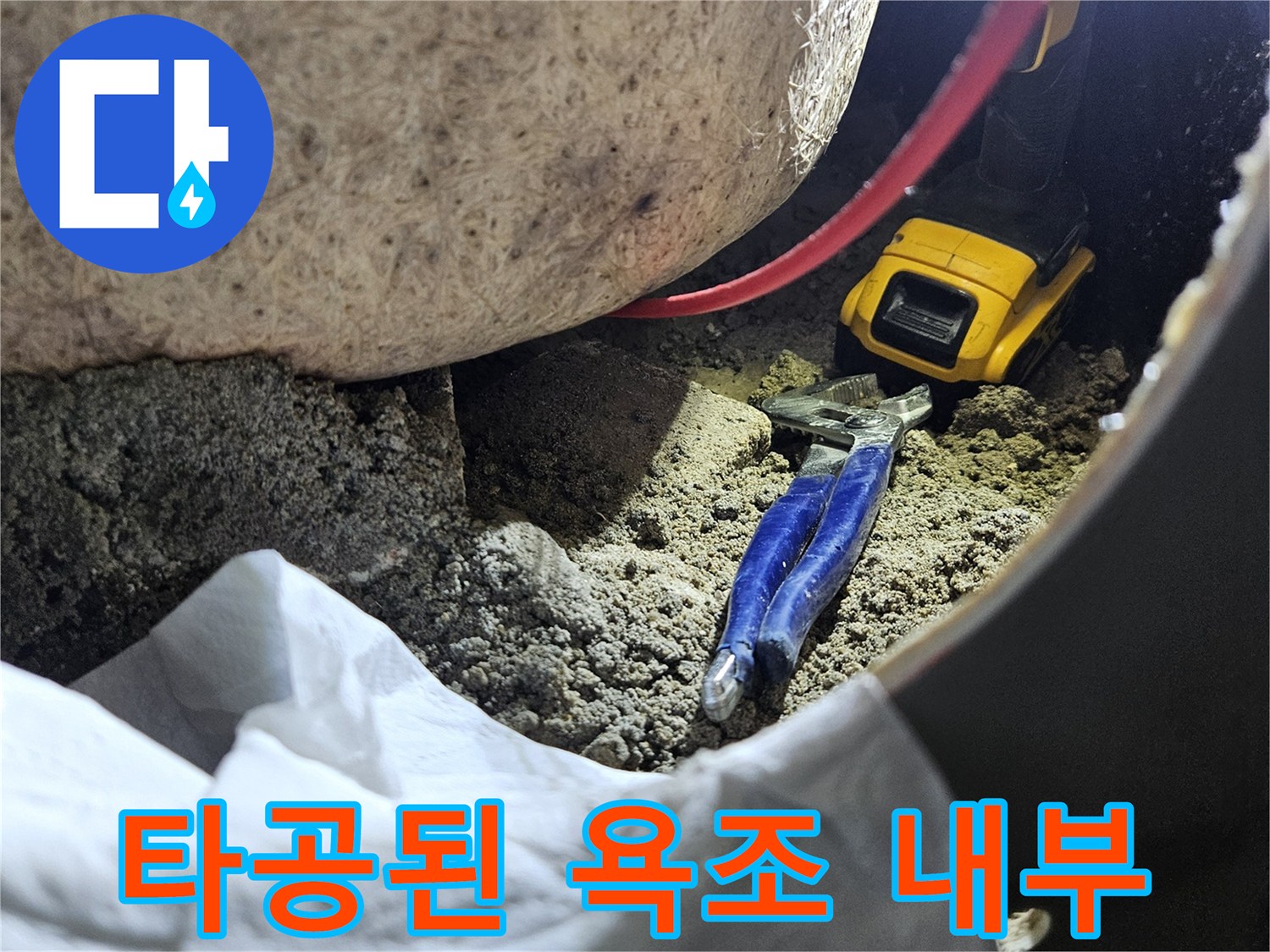 전동 드릴과 공구가 보이는 욕조 하부 배관 점검 부위