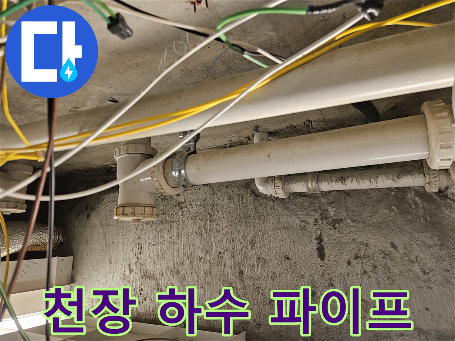 천장에 노출된 흰색 PVC 배관과 주변의 복잡한 전선들