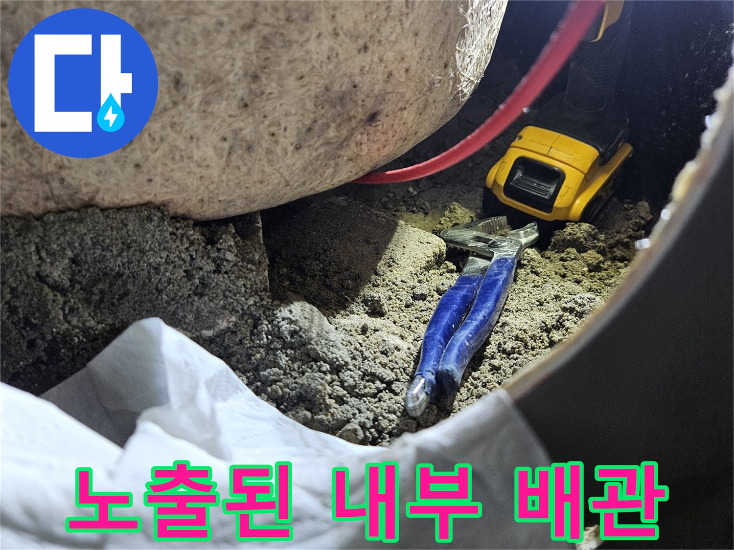 타공된 욕조 틈새로 보이는 배관 및 작업용 공구