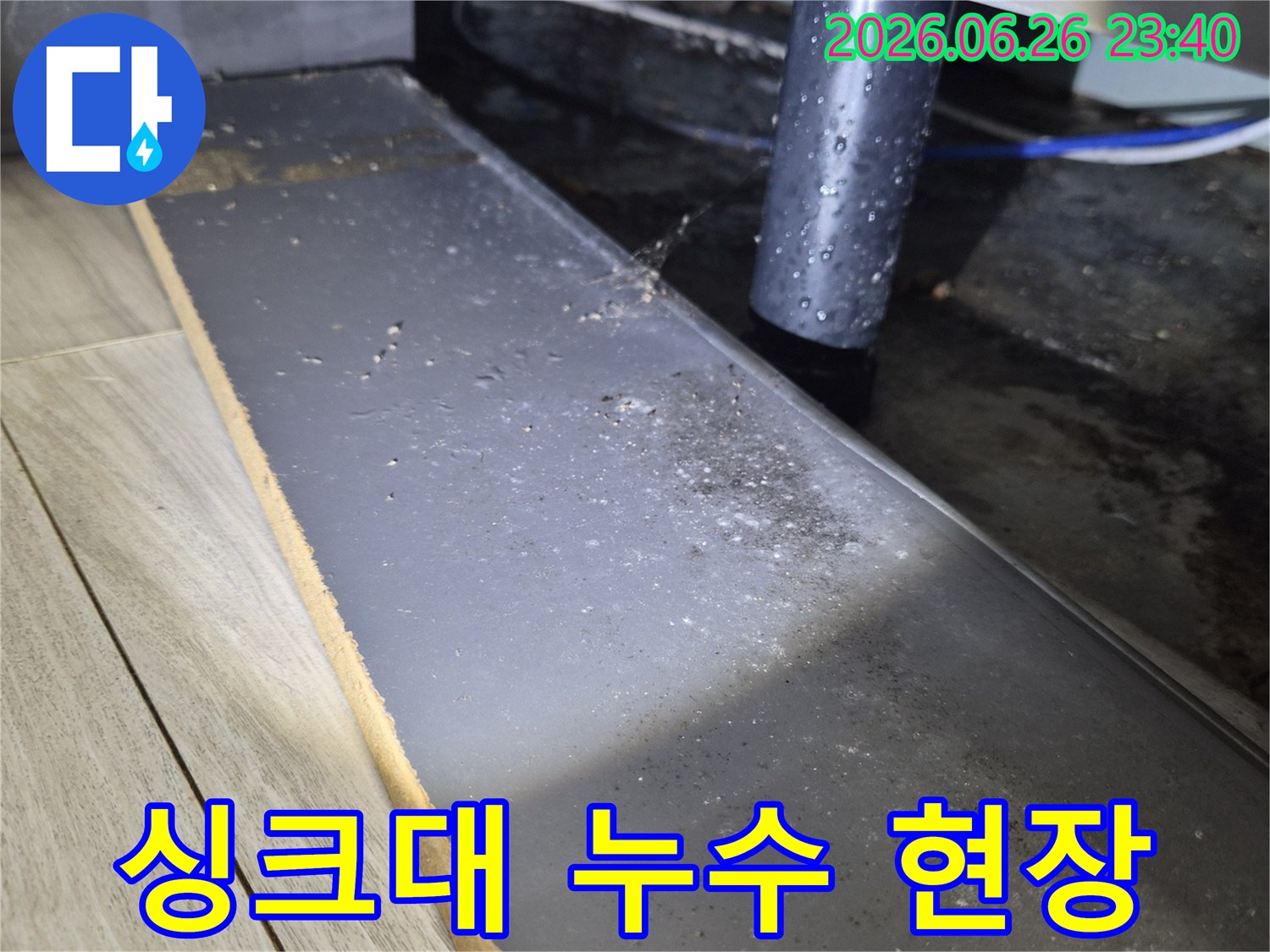 주방 싱크대 하부의 배수관에서 물이 새어-주변에 물기가 맺힌 모습을 보여주는 사진