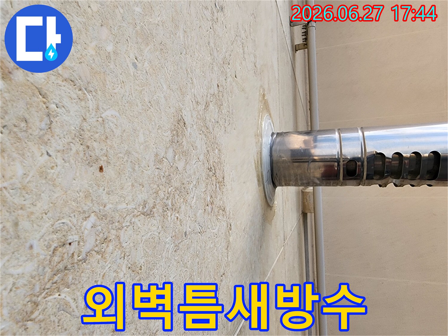 건축물-외벽에-고정된-파이프-주변으로-물기가-번져-있는-누수-현장-사진