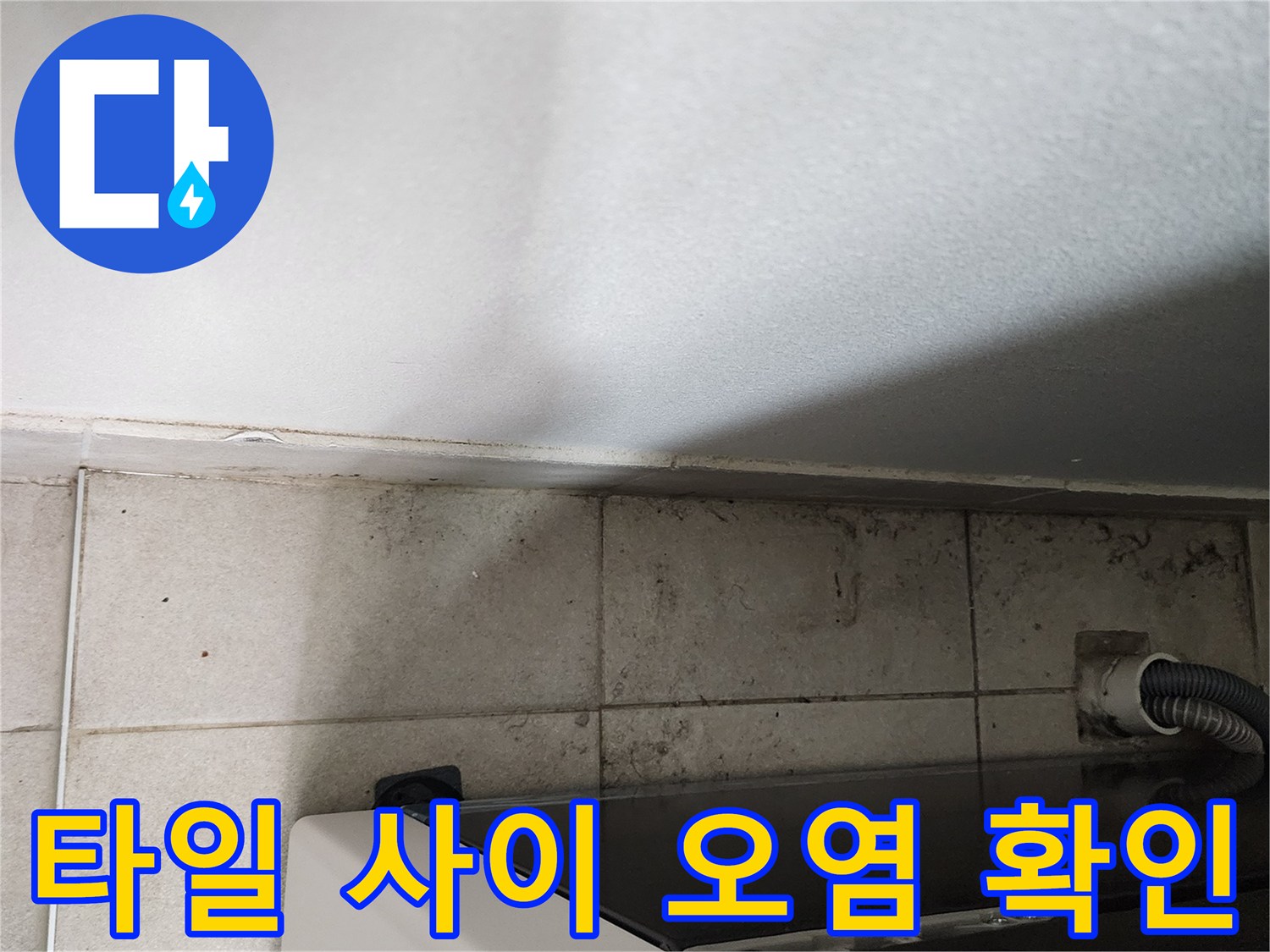 세탁기 옆 타일 틈새에 발생한 누수 흔적 및 변색된 부위