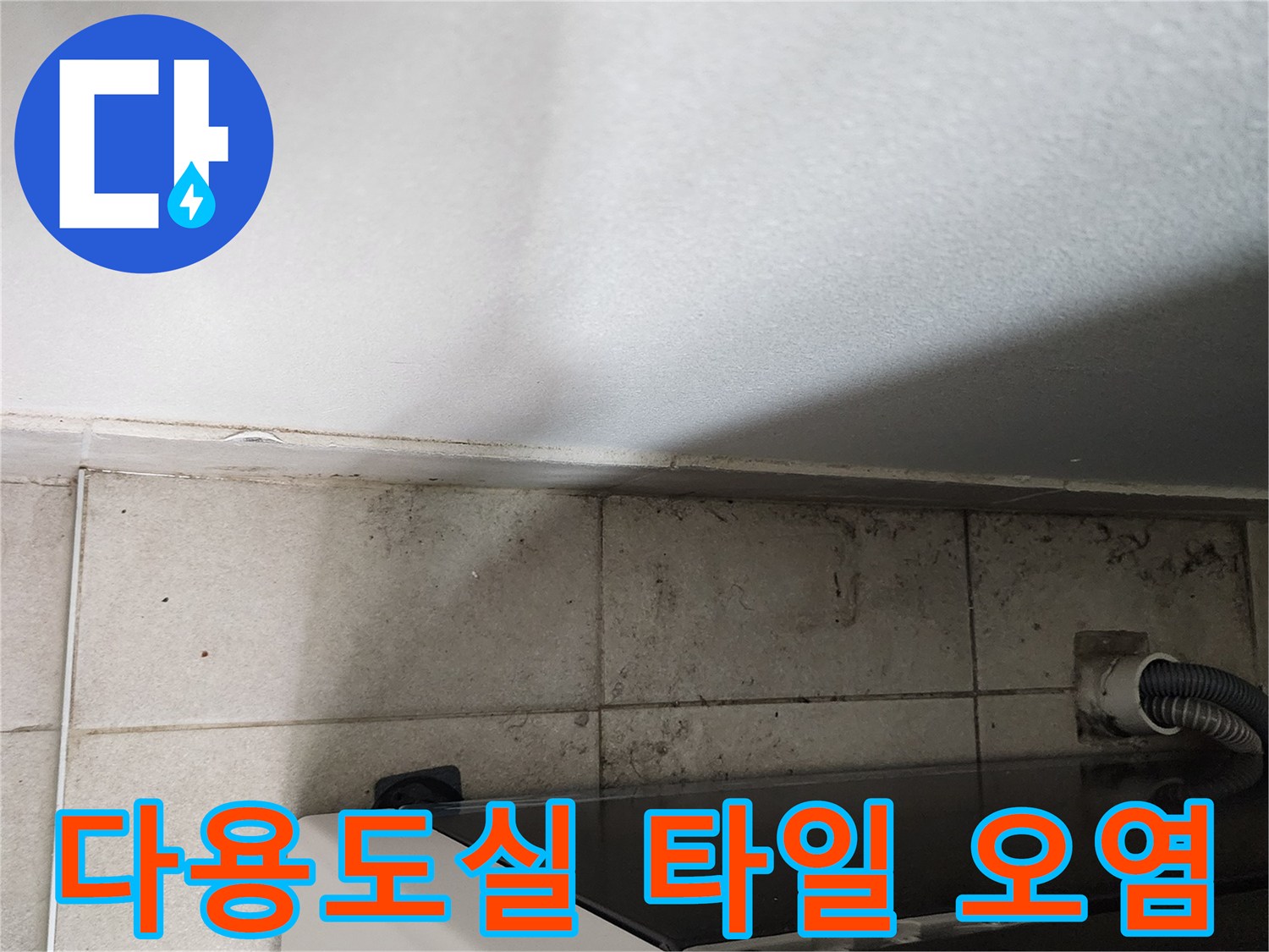 세탁기 주변 타일 틈새와 배수 호스 연결 부위 근접 촬영
