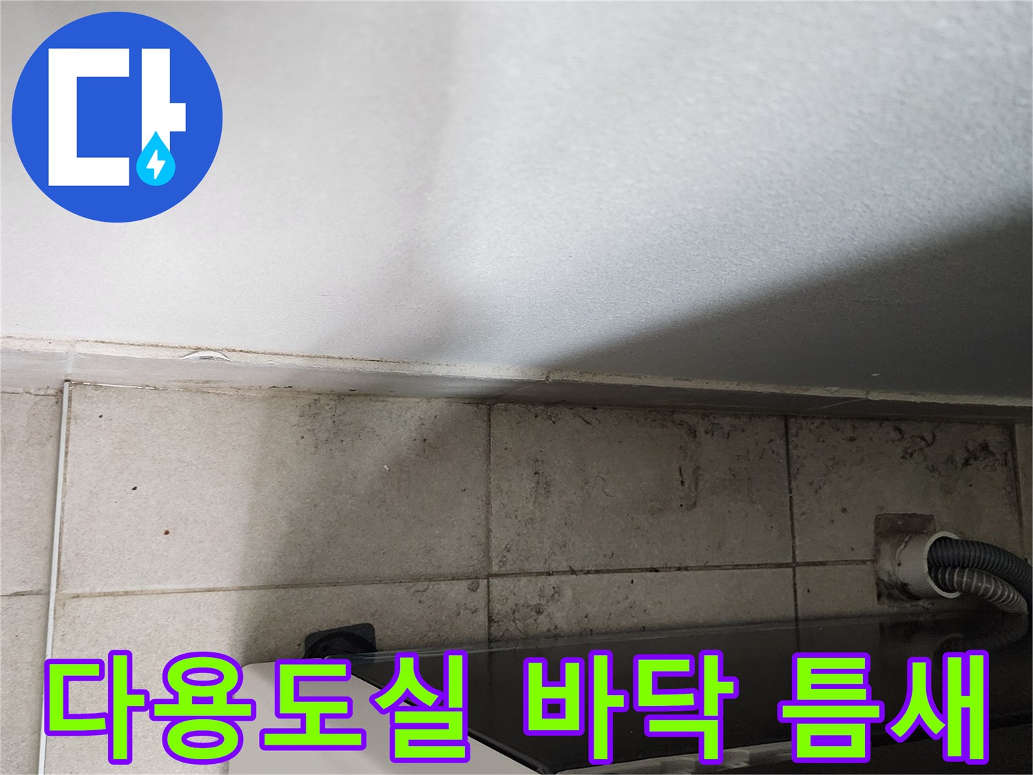 세탁실 타일 사이-배수 호스 연결 부위 근접 촬영