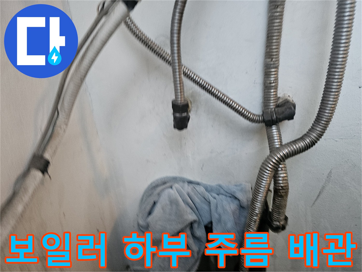 보일러 아래쪽 은색 주름관과 벽면 연결 지점 근접 촬영