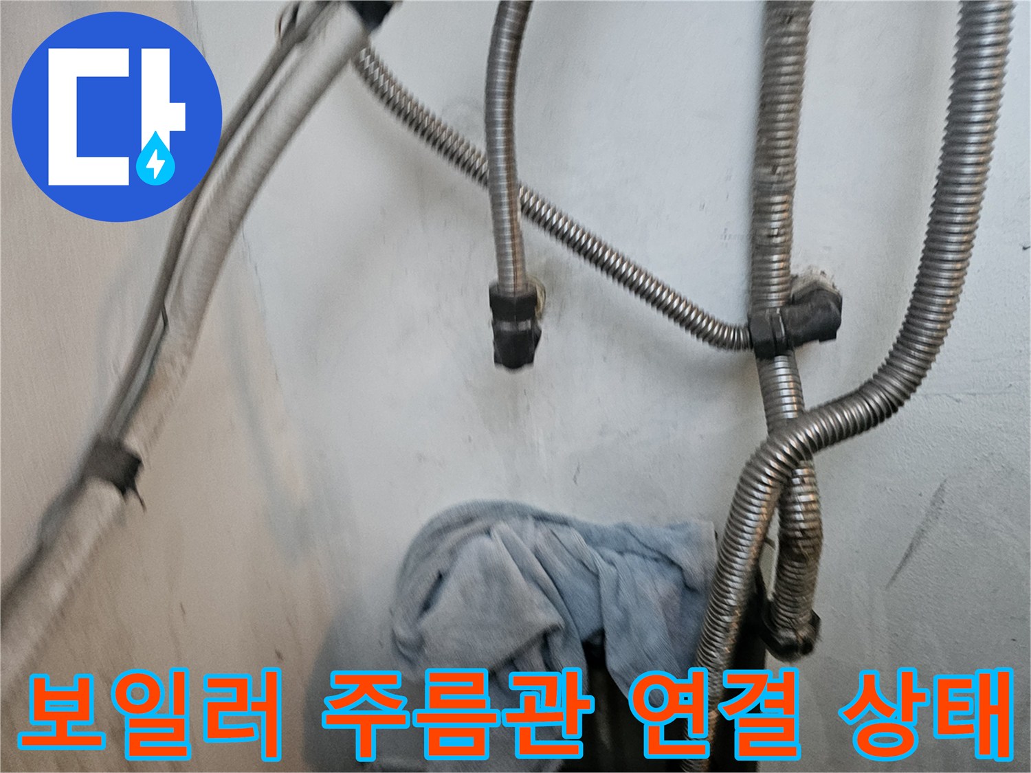 보일러 하단-금속 재질의 주름관과 배관 연결 부위 모습