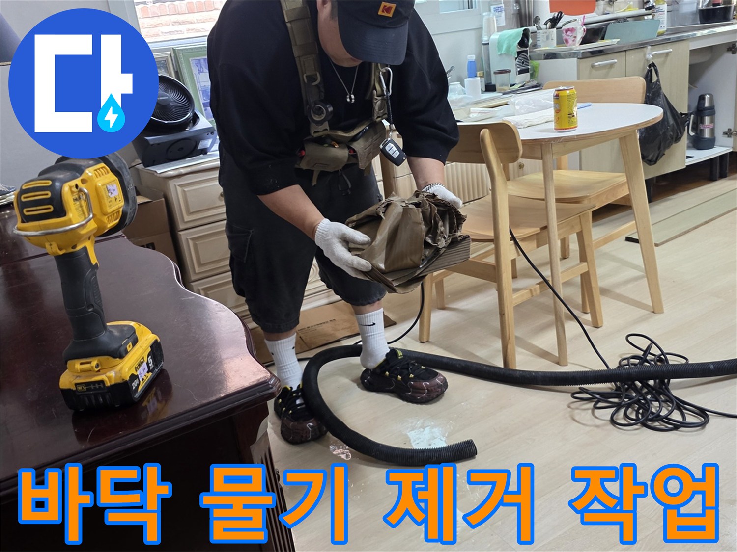 싱크대 배수관 주변의 고인 물을 청소기로 흡입하는 중입니다.