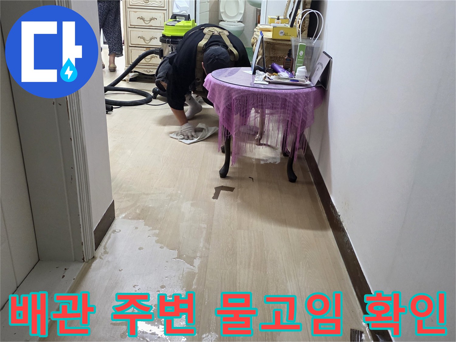 싱크대 배수구 주변에 고인 물을 제거하는 현장 사진입니다.