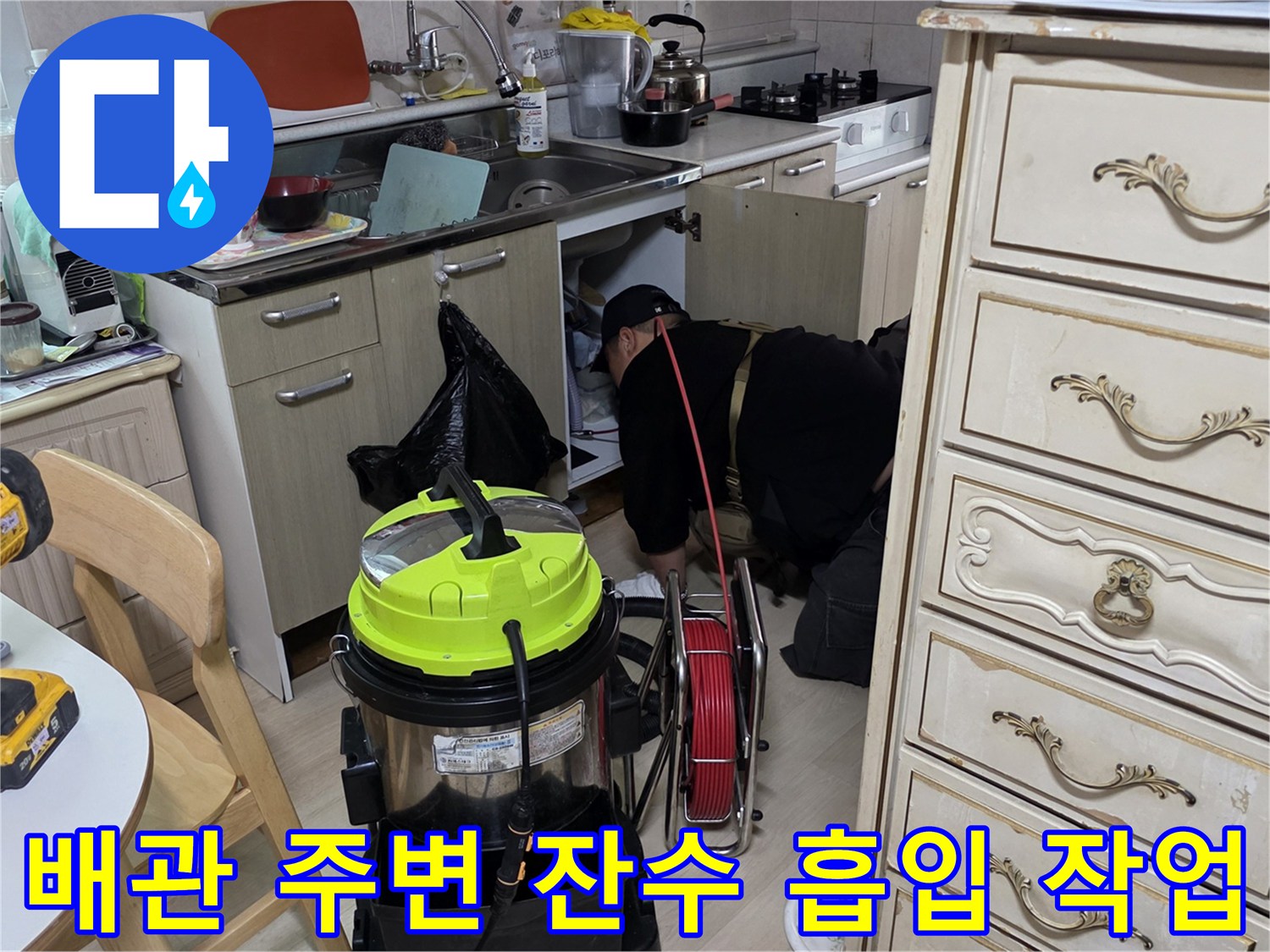 싱크대 아래쪽 젖은 바닥의 물기를 제거하는 전문 장비 사용 모습