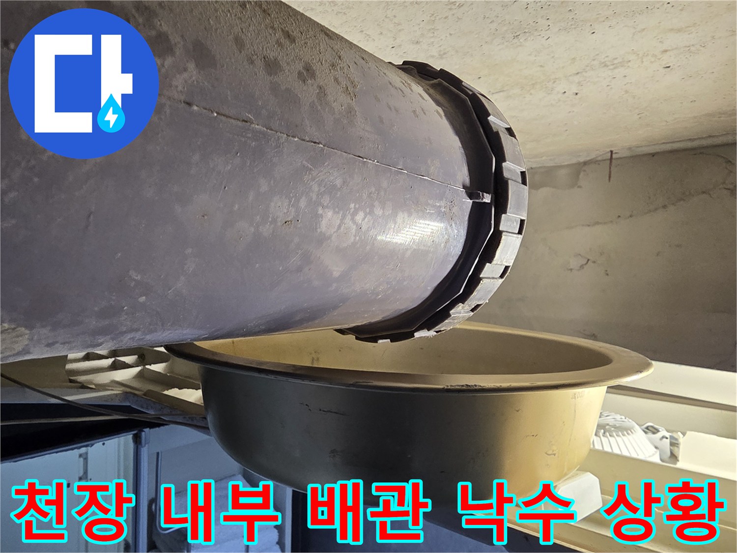 배관-연결부에서-떨어지는-물을-받고-있는-금속-대야