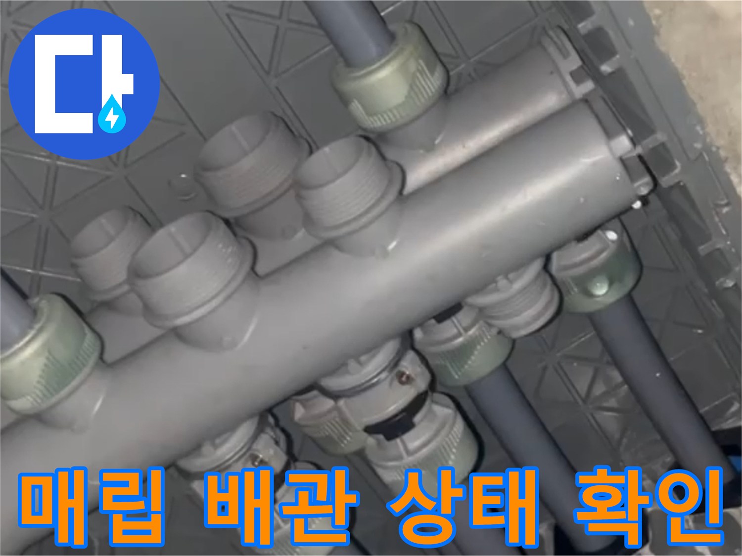 복잡하게 얽힌 회색 배관 분배기 부속들의 연결 부위를 근접 촬영한 사진입니다.