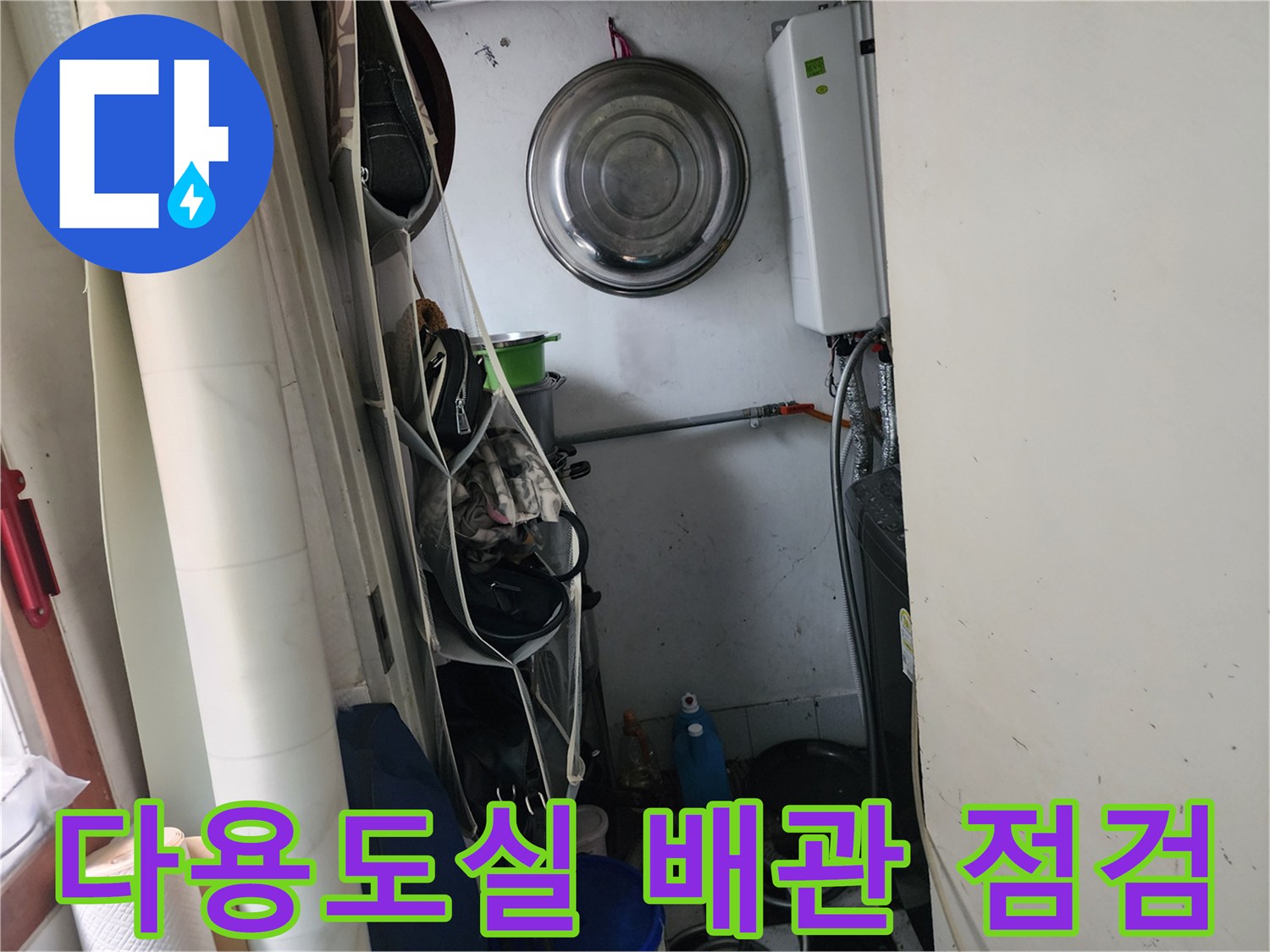 다용도실 벽면의 배관과 흰색 수납함 주변 모습