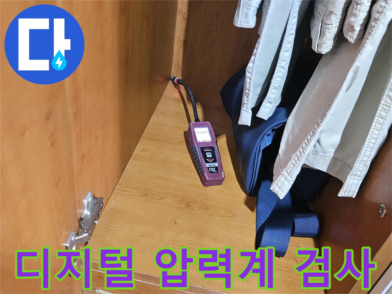 세면대 하부 가구 안쪽에서 진행 중인 배관 디지털 압력계 기밀 시험 장면입니다.