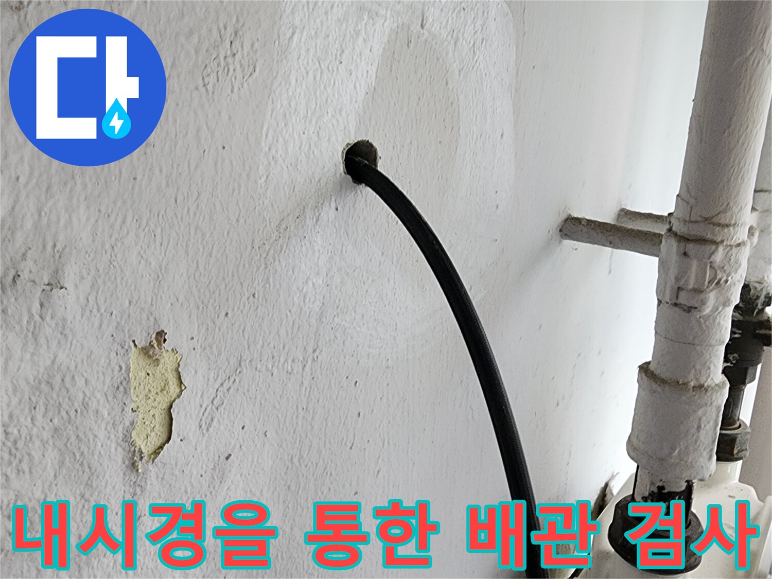 벽면 구멍 사이로 연결된 내시경 카메라 선