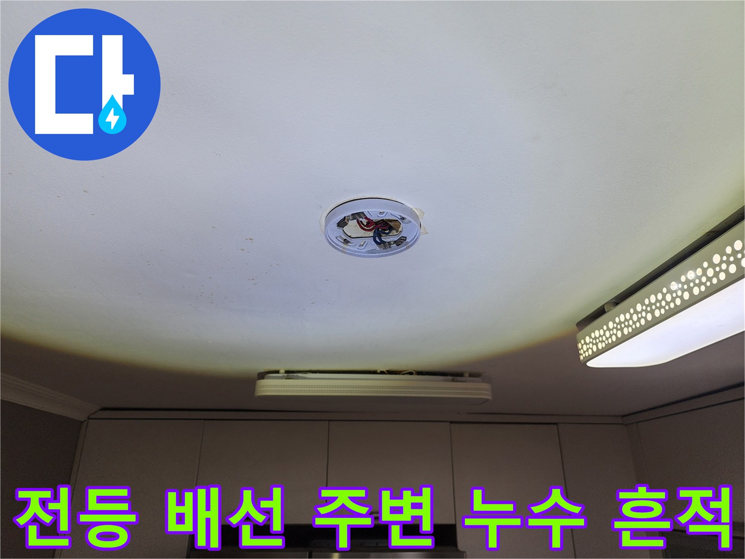 천장 전등 배선 구멍 근처의 젖은 듯한 변색된 마감재
