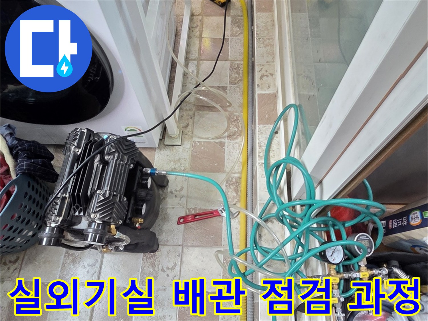 세탁실 바닥에 놓인-공기압 측정 장비와 연결된 배관 호스