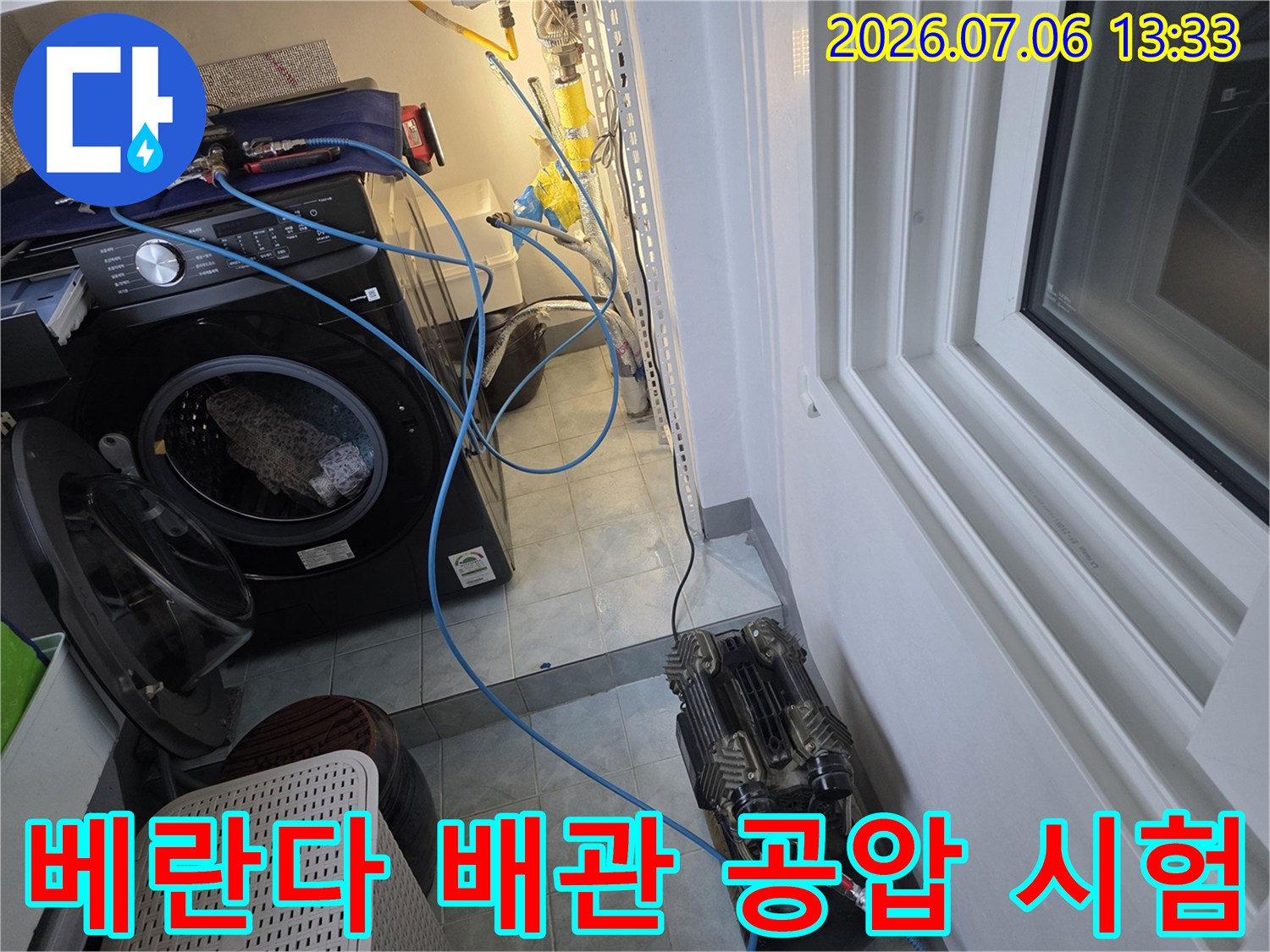 세탁실 내 노출된 배관 시스템에 공압 장치를 결합하여 점검하는 과정